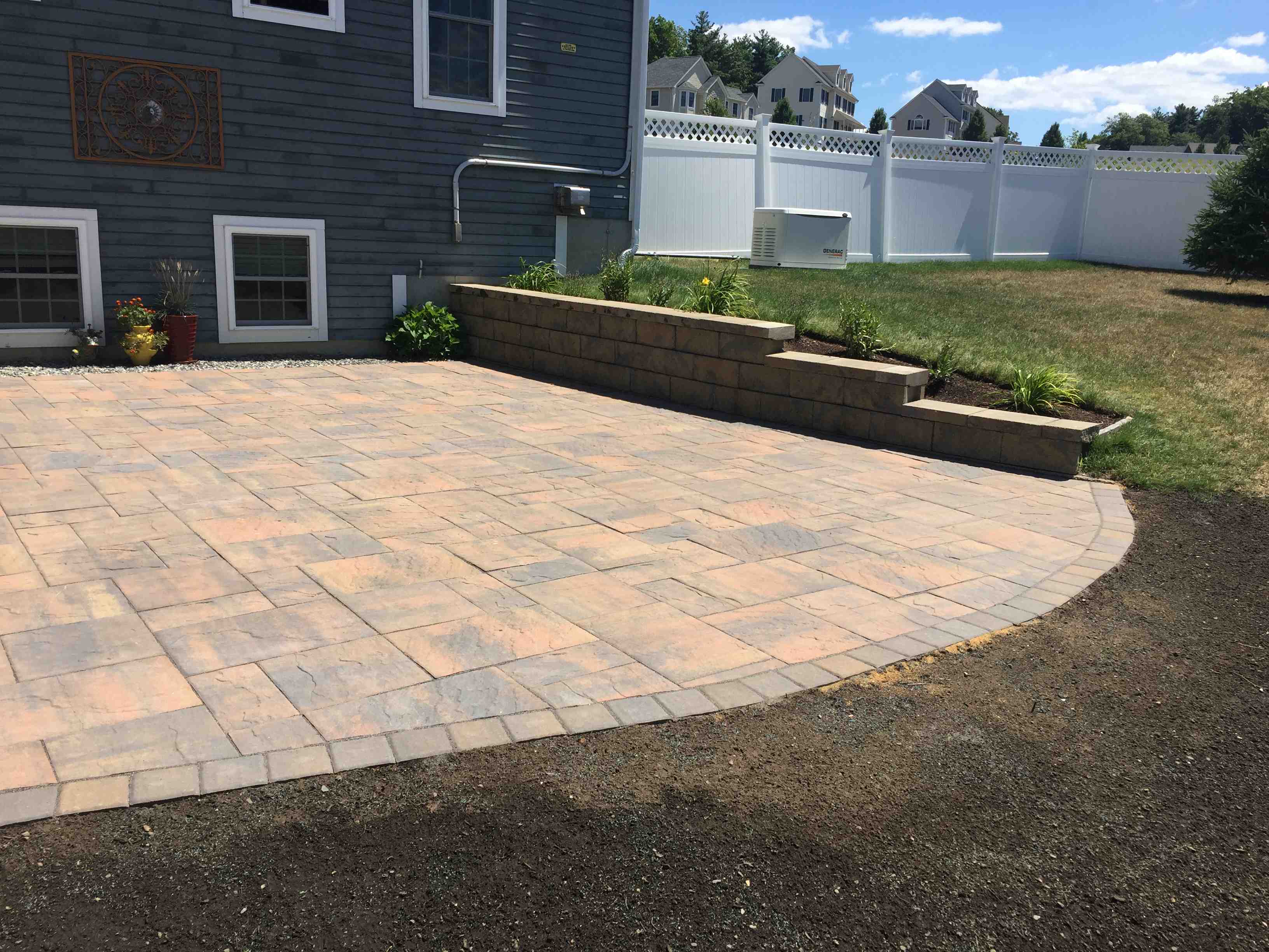 a multi-level paver patio with a curved retaining wall - outdoor patio designs