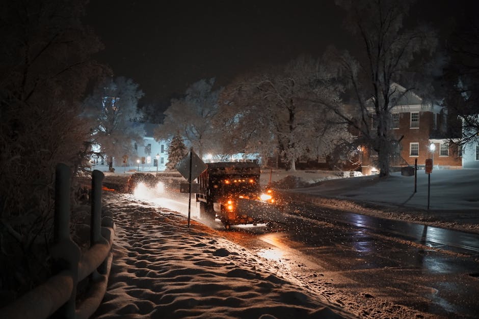 Snow plow clearing a snowy road - snow plow company near me